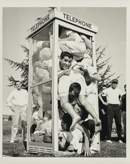 Twenty four students squeezing into a telephone booth during Homecoming, October 6, 1984