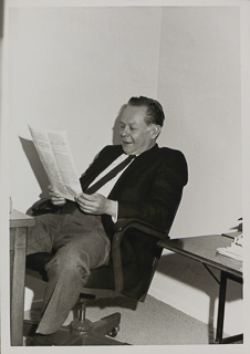 Professor of Economics William Tauchar sitting at a desk, 1970