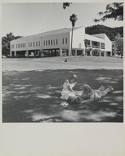 Students sitting on the grass in front of Saint Albert Hall Library, 1970