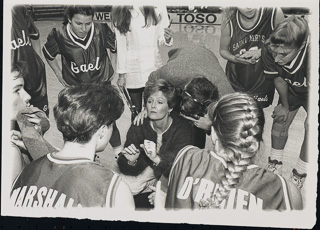 Coach Terri Rubenstein in the center of a women&#39;s basketball team huddle, 1991