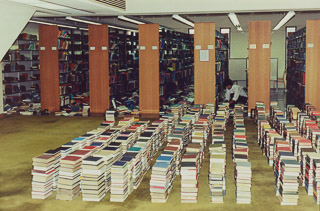 A library staff member picks up books in the Saint Mary&#39;s Library following the 1989 Loma Prieta earthquake, 1989