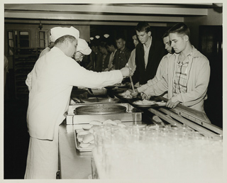 Students being served food at the cafeteria in Oliver Hall, 1957