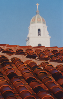 Closeup of tile roof of the Brothers&#39; Residence with the chapel bell tower in background, undated