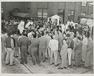 Herman Wedemeyer in center of a crowd waiting for a plane to land, 1946