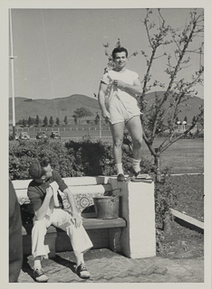 A student sits on a bench while another student stands on it, 1948