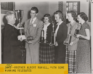 Brother Albert Rahill presenting students with a trophy at the Western Catholic High Schools Press Convention, 1951