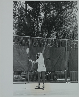 Young woman hitting a serve on a tennis court, 1981